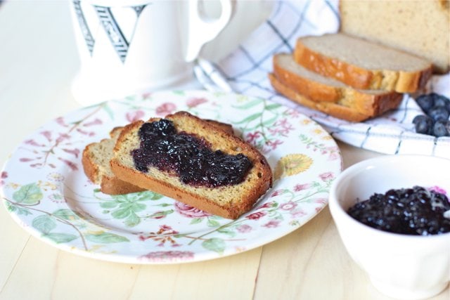 Homemade Blueberry Preserves without Pectin on grain free bread on a plate with two slices cut in the background
