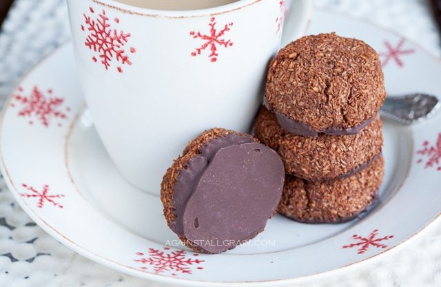A cup of coffee accompanied by a plate full of chocolate peppermint macaroons.