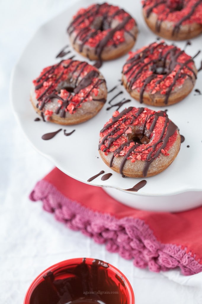 strawberry donuts drizzles with chocolate served on a white platter