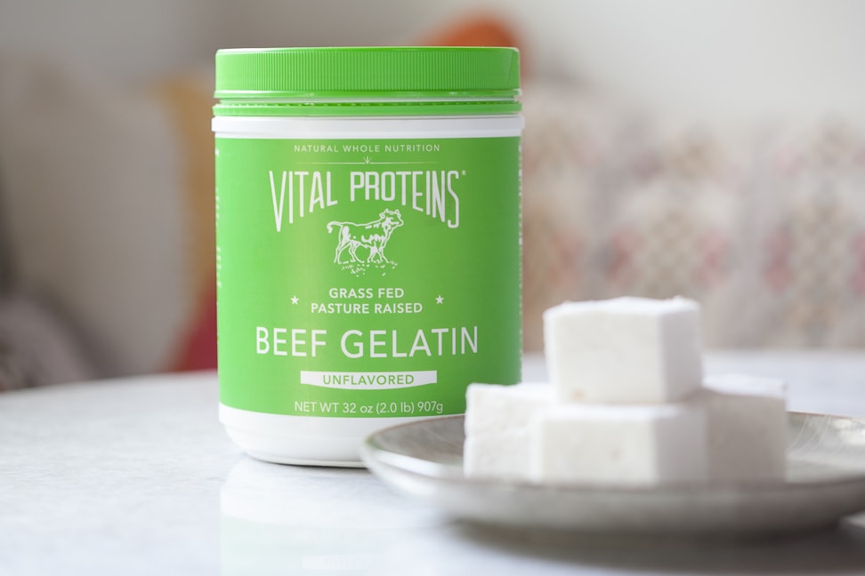 homemade gluten-free marshmallows on a white platter with a tub of Vital Proteins Beef Gelatin next to it