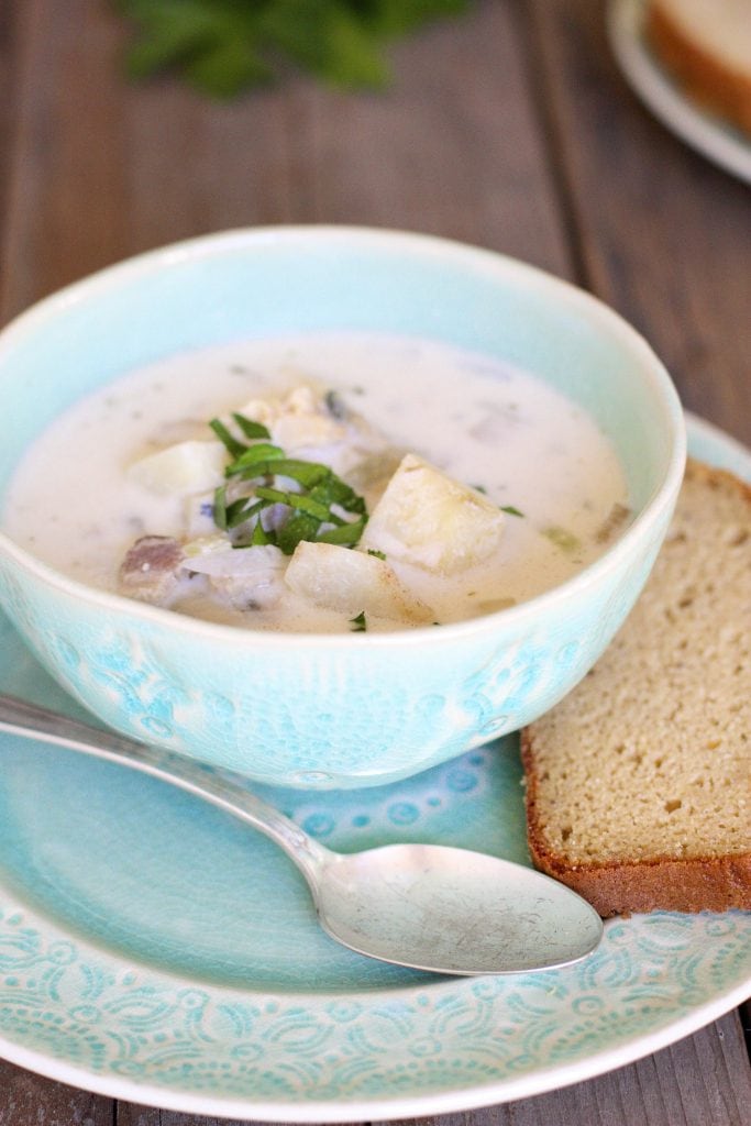 dairy-free clam chowder served in a light blue dinnerware set on a wooden table