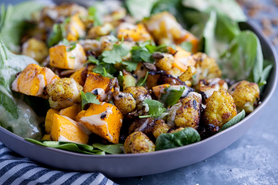 Cauliflower and Mango salad on a bed of spinach topped with tahini dressing.