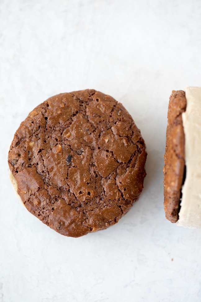Up close view of brownie cookie ice cream sandwiches displayed on a white counter