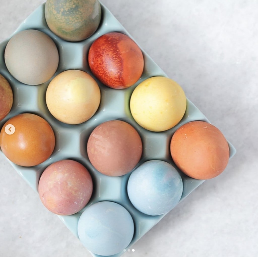 pastel dyed eggs in a light blue egg platter that sits on a white surface