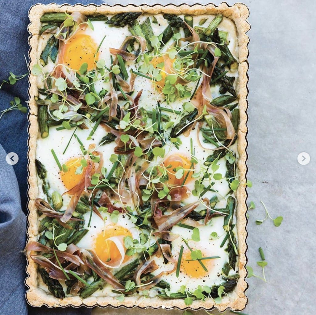 Asparagus tart in rectangle pan placed vertically on a gray table