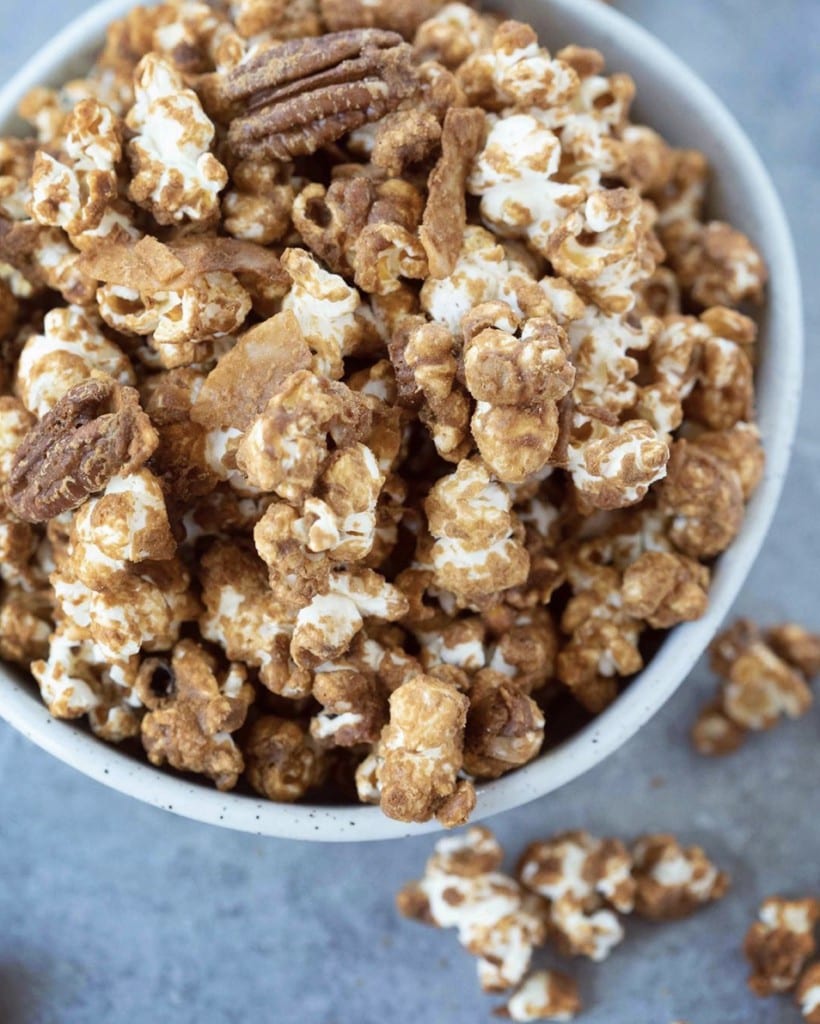 Up close view view of caramel corn with pecans and coconut flakes in a bowl