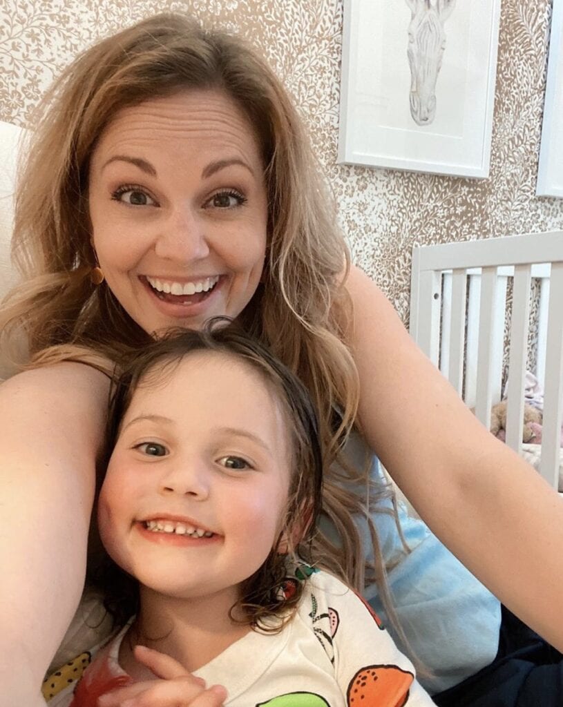 Mother and daughter smile directly at camera