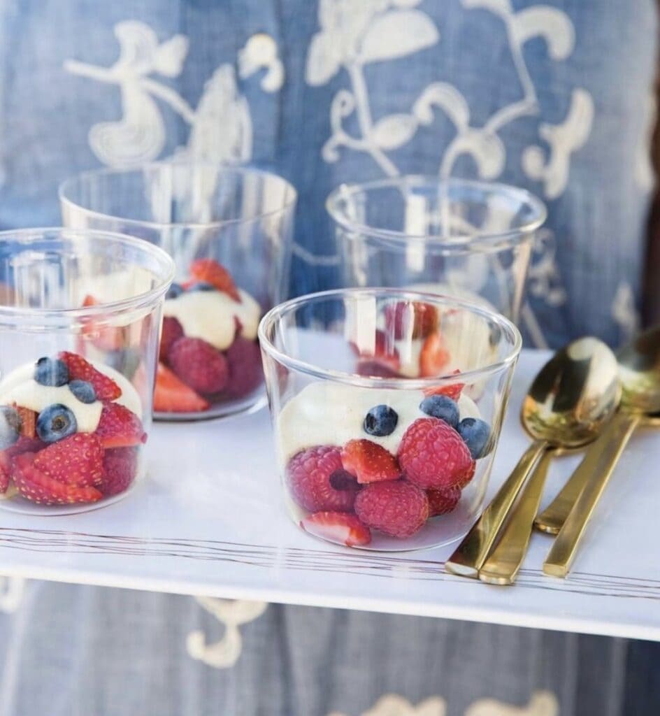 clear plastic cups filled with strawberries, blueberries, raspberries and vanilla custard